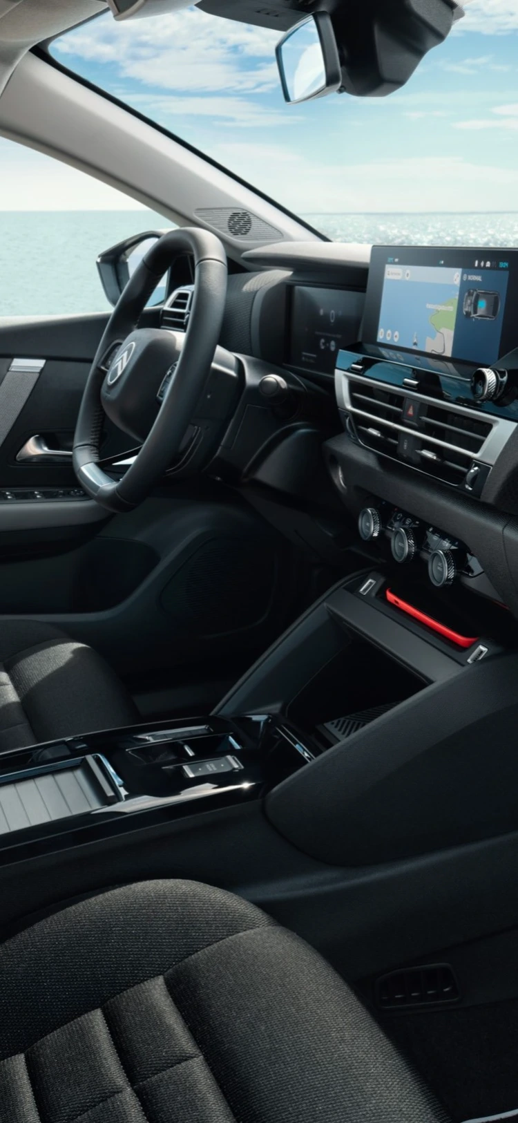 Abitacolo anteriore della Citroën C4 X con plancia e sedili sullo sfondo del mare