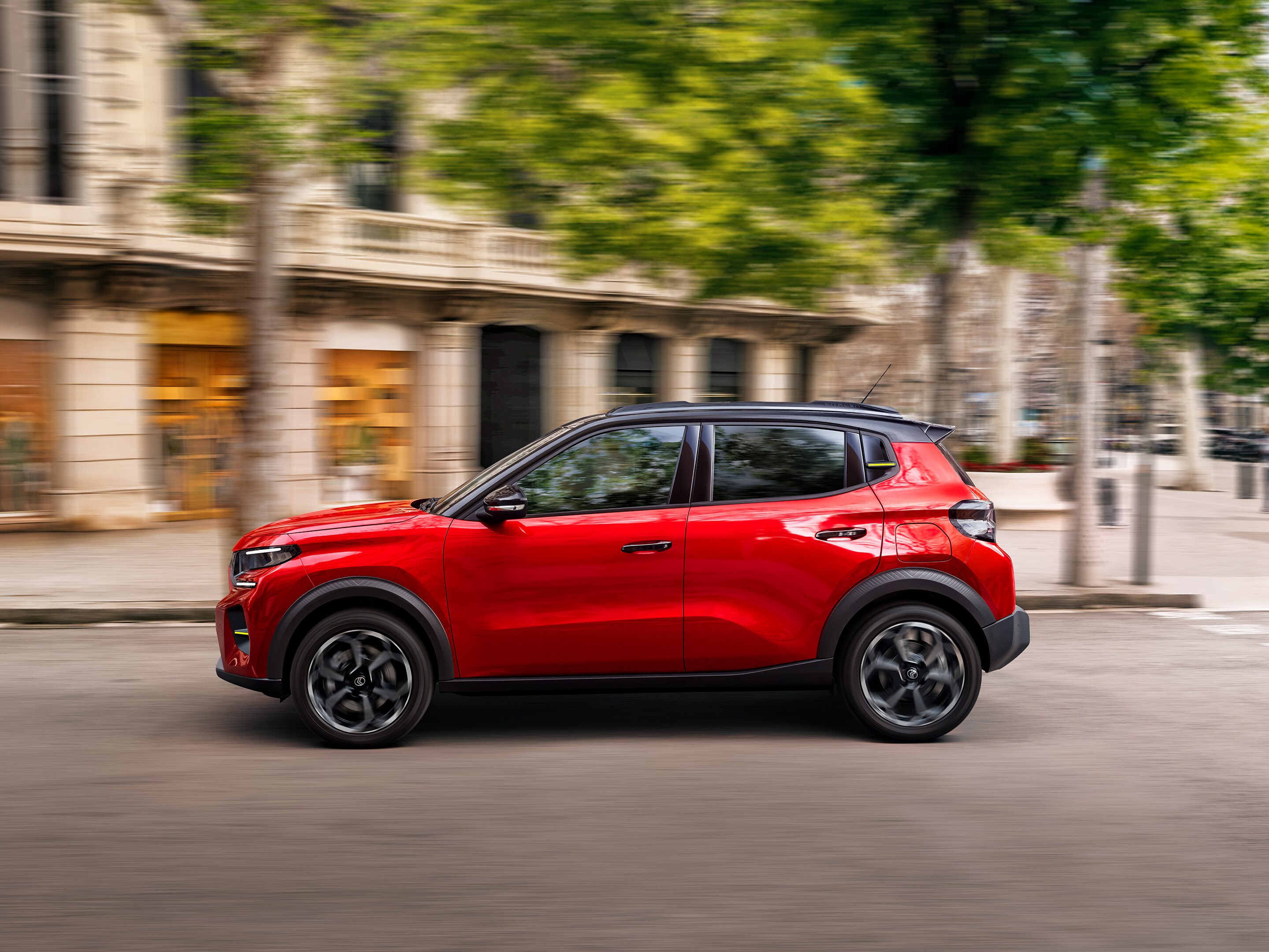 Vista laterale di Citroën ë-C3 che mostra la guida urbana dinamica, per una mobilità quotidiana fluida, pratica e accessibile.