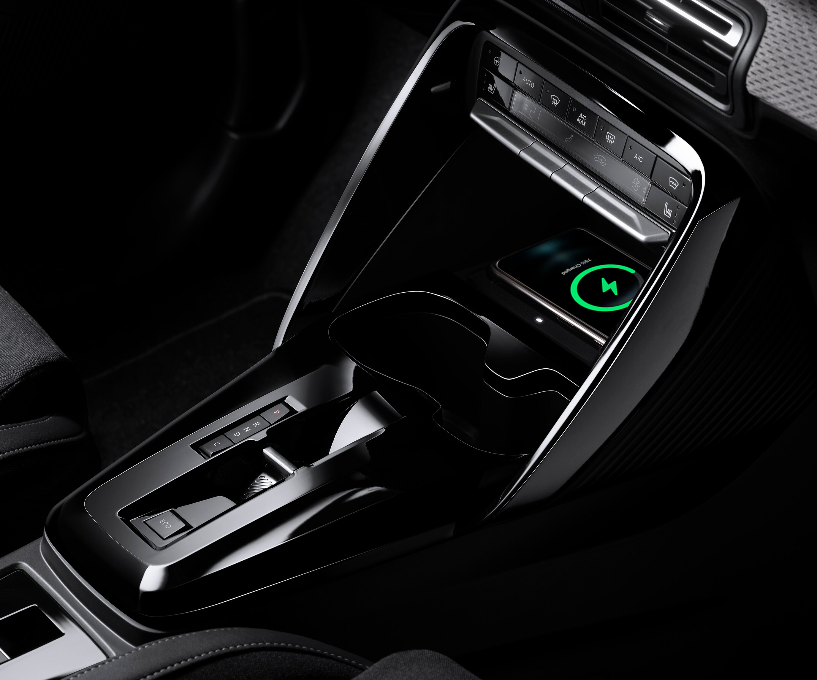 Vista ravvicinata della console di Citroën ë-C3 che mette in evidenza la ricarica wireless dello smartphone, per una mobilità quotidiana pratica e accessibile.