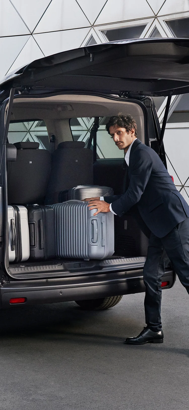 Rear of the Citroën SpaceTourer open as people load multiple suitcases, showing generous cargo capacity